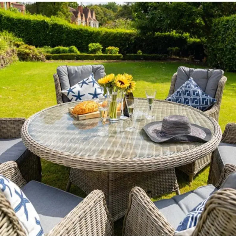 Outdoor patio set with round table and chairs in a garden setting