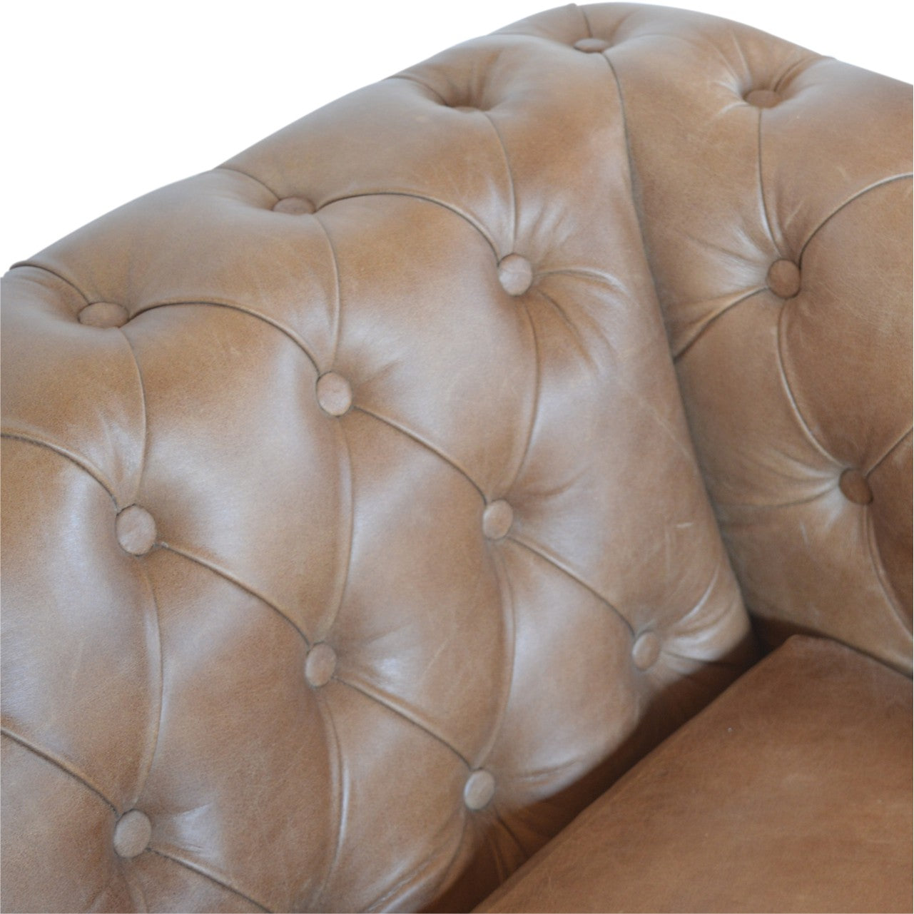 Buffalo leather chesterfield sofa. Close-up of a brown leather sofa with tufted backrest