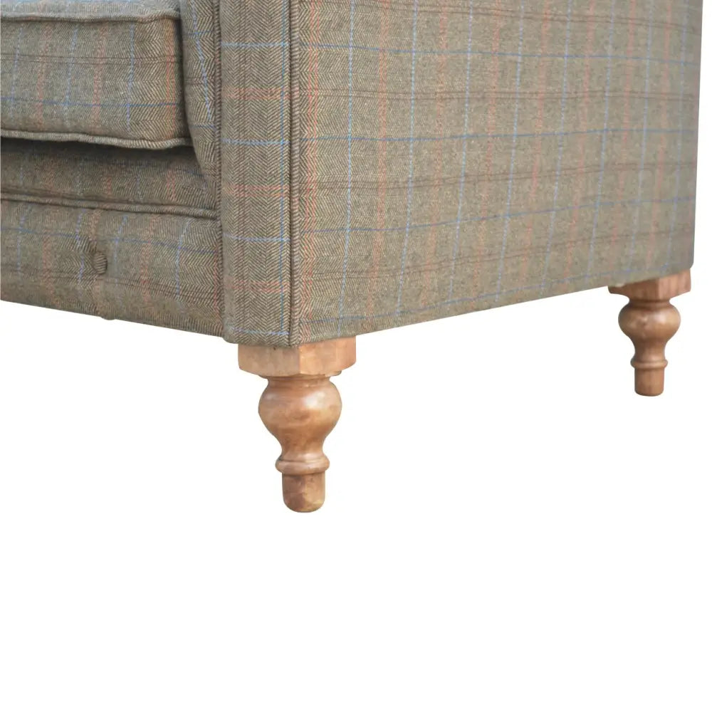 Tweed chesterfield sofa. Close-up of a sofa with wooden legs 