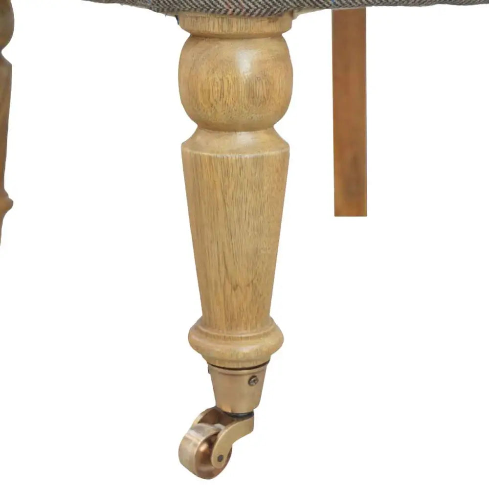 Tweed occasional chair Close-up of a wooden chair leg with a caster wheel 