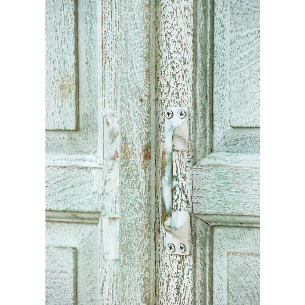 Tall Hand Painted Cupboard. Close-up of a textured wooden door with a metal handle.